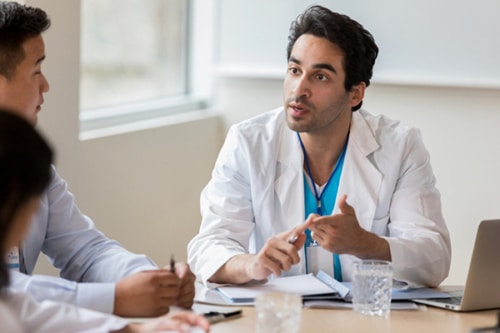 Doctor talking assertively in a meeting