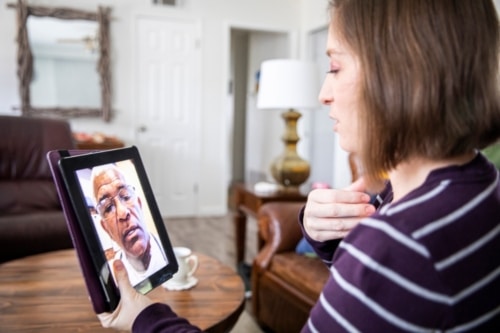 Patient using a tablet to have a telehealth appointment with her doctor